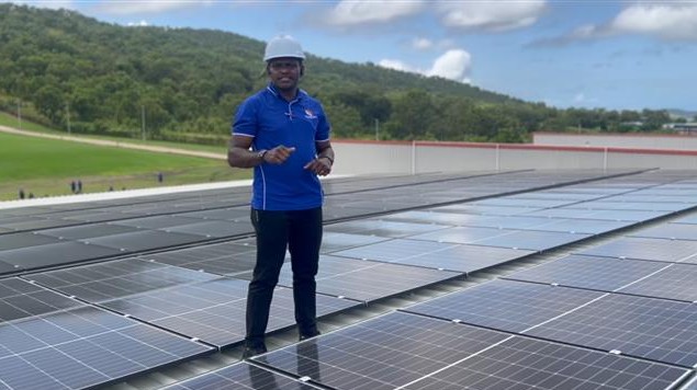 PNG Solar Supply representative standing on the SPIA rooftop solar array